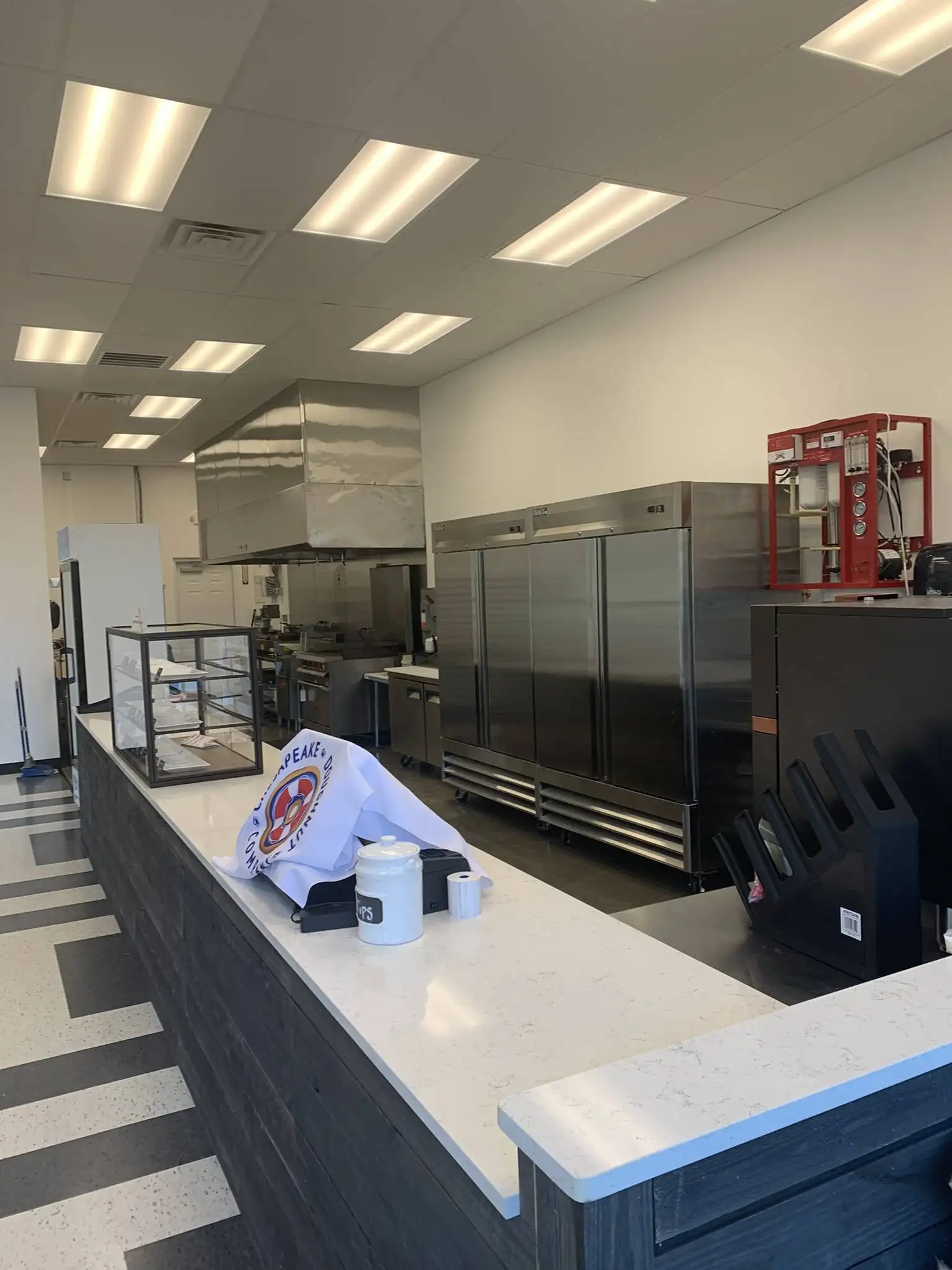 Storefront countertop with small display case and commercial kitchen hood in background